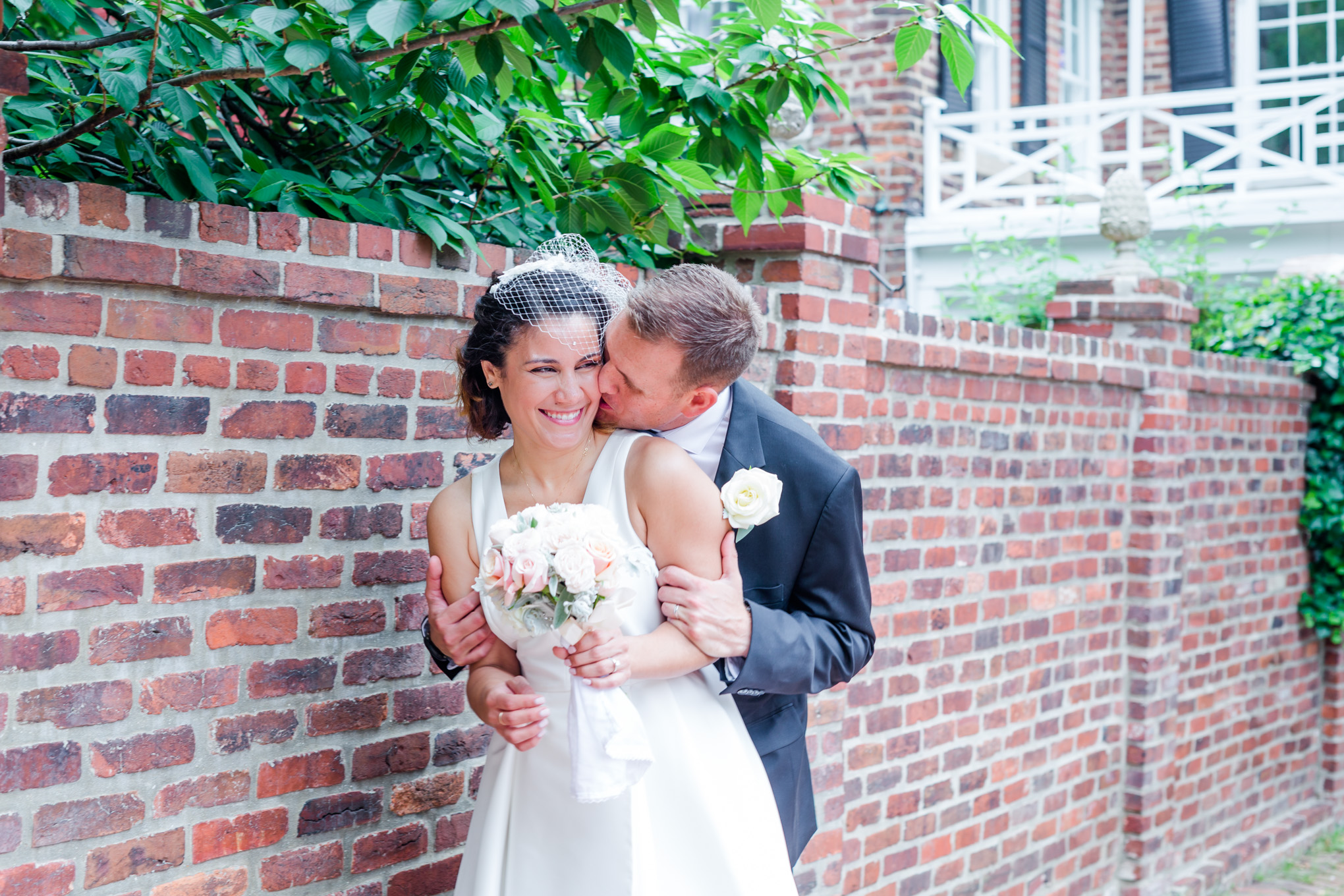 photography ready wedding venues, bride and groom, wedding portraits, portrait locations, old town Alexandria, northern VA wedding venues, Morrison House, Morrison House wedding, kissing pic, a-line wedding gown, surprise kiss, brick wall