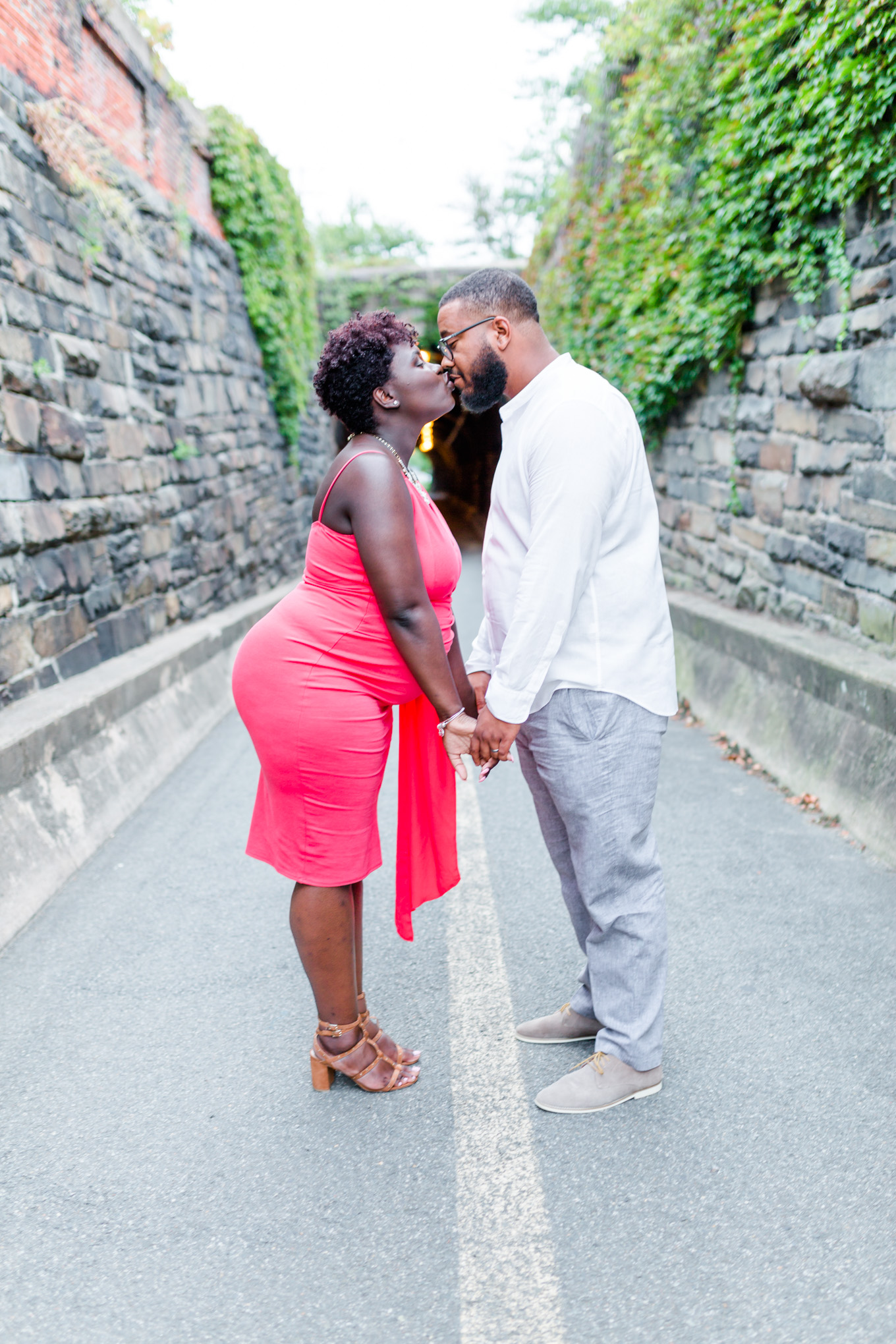 Wilkes Street Tunnel maternity photos, maternity style, coral dress, married couple, mom to be, dad to be, old town Alexandria, northern Virginia, maternity photographer, Alexandria maternity photographer, magic hour portraits, kissing couple