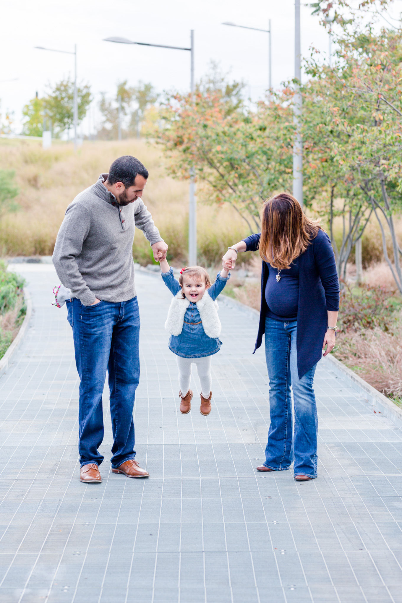 long bridge park family photos, family of three, toddler, little girl, baby bump, maternity photos, outdoor photos, holiday portraits, family portraits, northern Virginia, magic hour portraits, swinging picture
