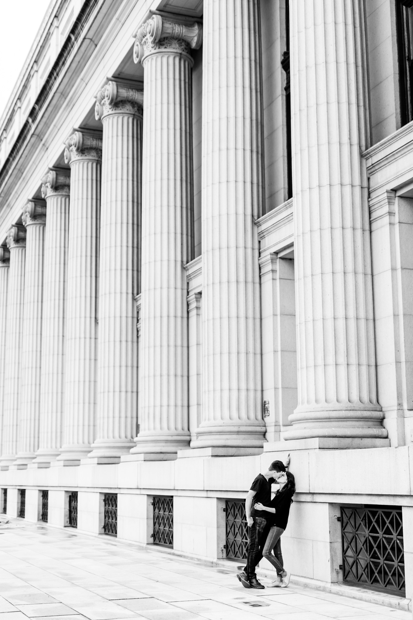 black and white engagement photos, black and white photography, black and white photos, engagement photos, black and white D.C., D.C. engagement photos, classic engagement photos, traditional engagement photos, engagement photos poses, classic architecture, D.C. architecture, Union Station D.C., Union Station, engaged couple, relationship goals, joyful couple, black and white sessions, Postal Museum, couple kissing, couple leaning on wall