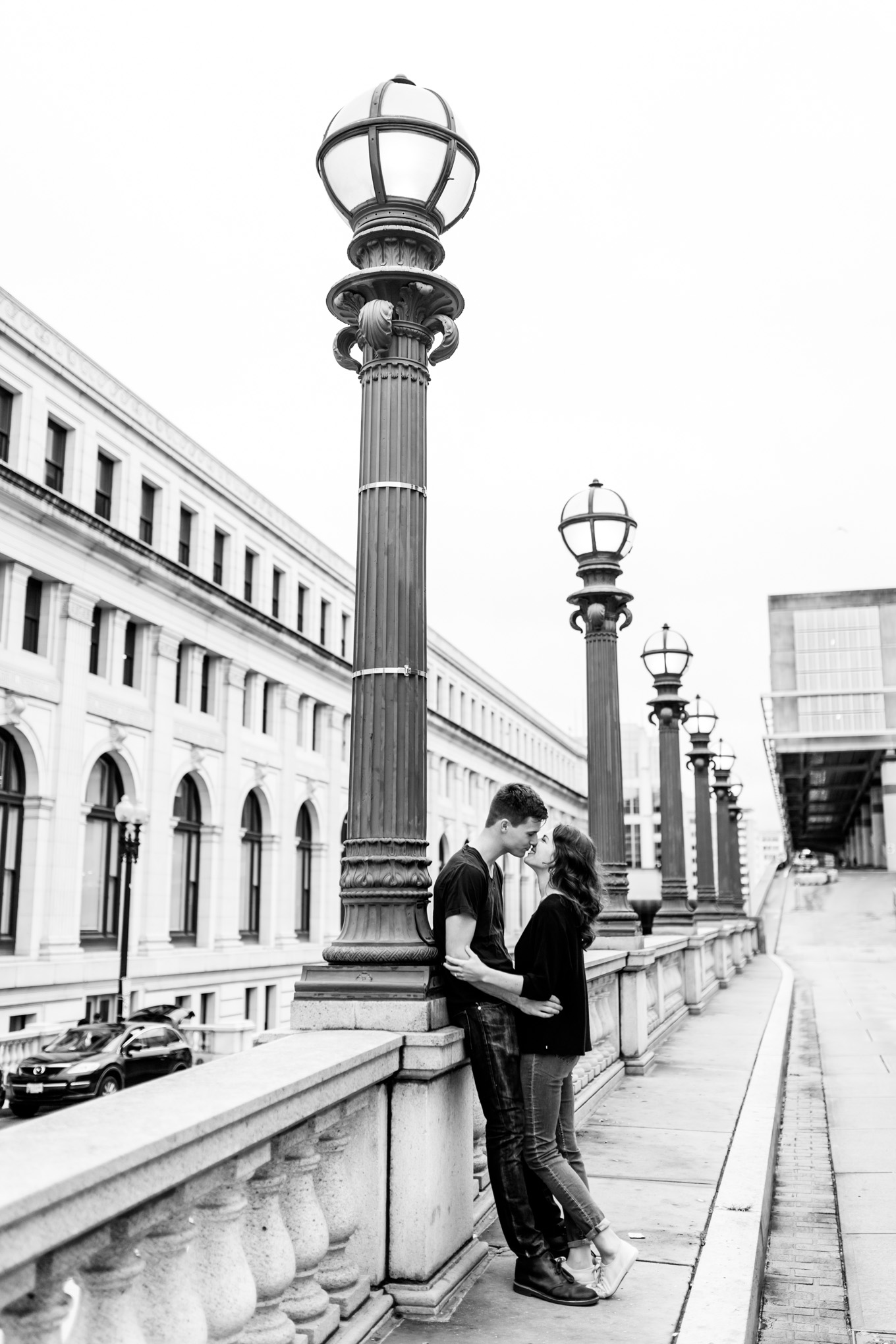black and white engagement photos, black and white photography, black and white photos, engagement photos, black and white D.C., D.C. engagement photos, classic engagement photos, traditional engagement photos, engagement photos poses, classic architecture, D.C. architecture, Union Station D.C., Union Station, engaged couple, relationship goals, joyful couple, black and white sessions, couple leaning on lamp post, Postal Museum
