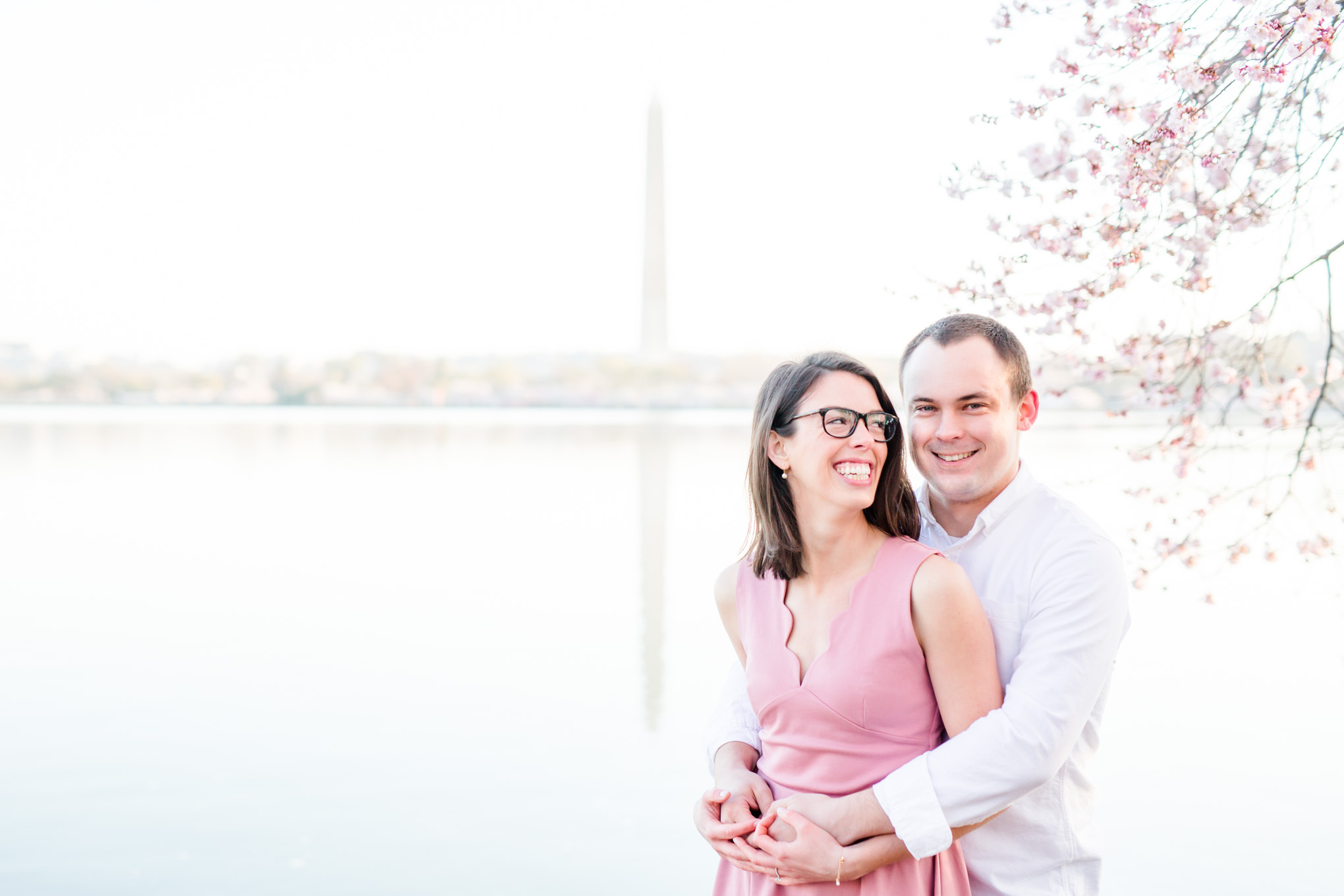 sunny cherry blossoms engagement session, Washington, D.C. engagement photos, Washington D.C. engagement photos, sunrrise engagement photos, cherry blossom engagement photos, D.C. cherry bloossoms, D.C. cherry blossoms photos, cherry blossom photos, cherry blossoms portrraits, sunny engagement photos, classic engagement photos, Rachel E.H. Photography, engagement session style, couple laughing, Washington Monument