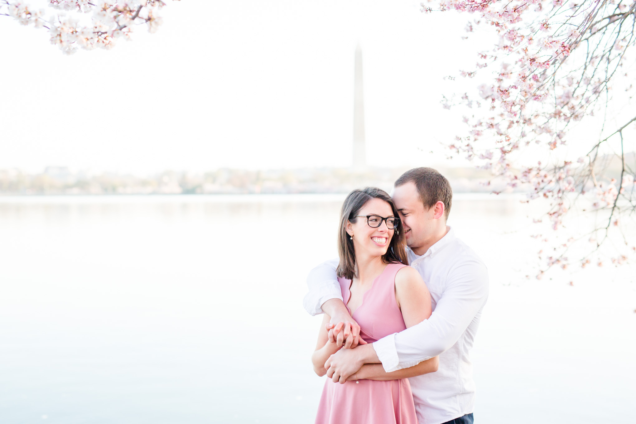 sunny cherry blossoms engagement session, Washington, D.C. engagement photos, Washington D.C. engagement photos, sunrrise engagement photos, cherry blossom engagement photos, D.C. cherry bloossoms, D.C. cherry blossoms photos, cherry blossom photos, cherry blossoms portrraits, sunny engagement photos, classic engagement photos, Rachel E.H. Photography, engagement session style, couple snuggling, Washington Monument