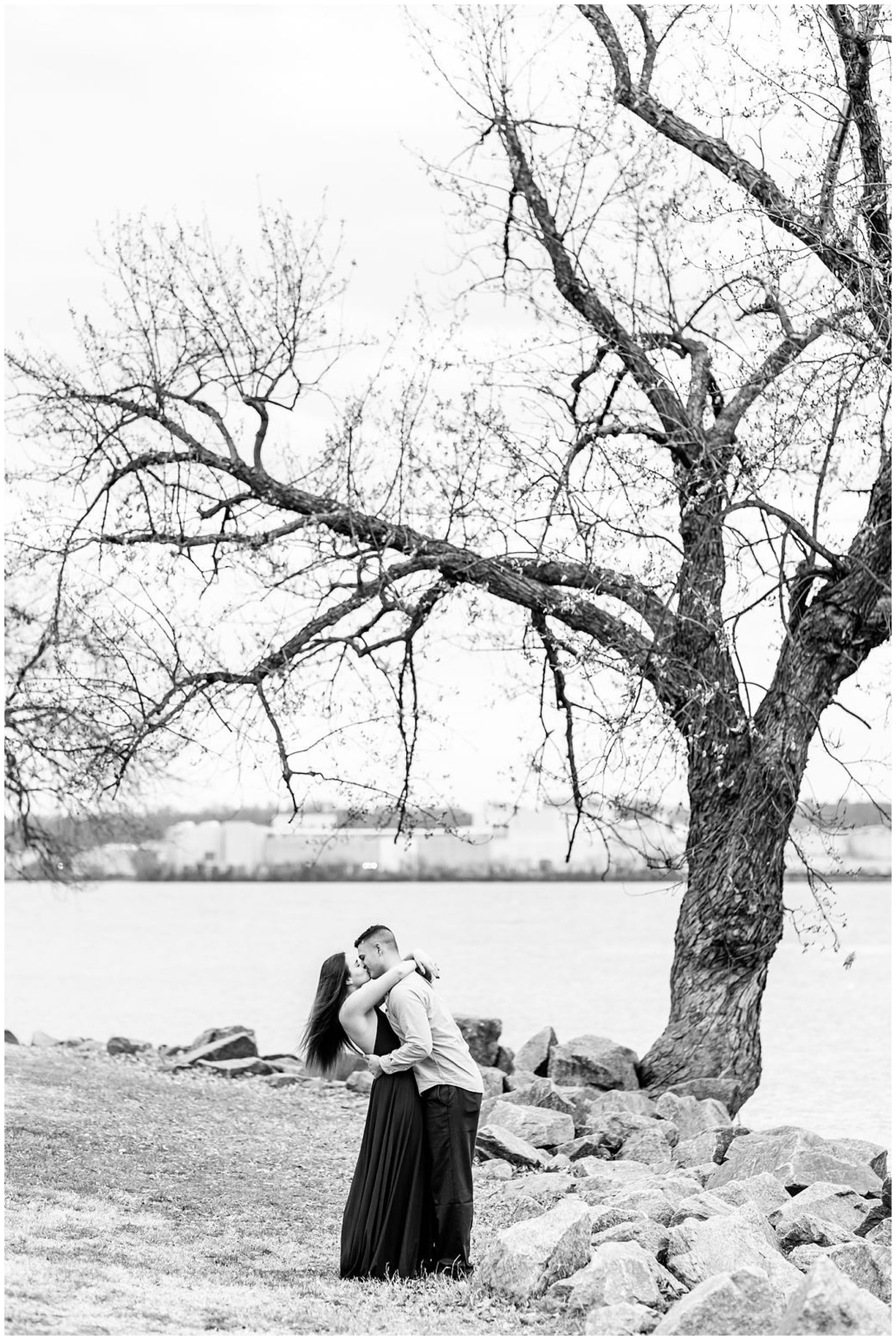 winter Alexandria engagement session, Alexandria engagement photos, Alexandria Virginia portraits, Old Town Alexandria engagement photos, winter engagement photos, Christmas engagement photos, semi-formal engagement photos, Rachel E.H. Photography, black and white, couple kissing on shore, couple kissing in front of tree
