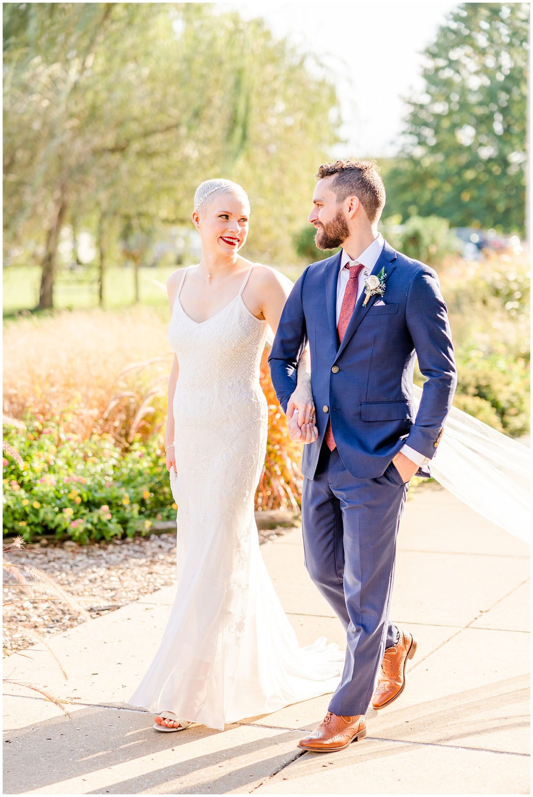 ethereal Rawlings Conservatory wedding, Baltimore wedding venues, Baltimore wedding photographer, Baltimore micro-wedding, Baltimore wedding photography, autumn wedding aesthetic, botanical gardens wedding, Baltimore botanical garden wedding, DC wedding photographer, Rachel E.H. Photography, couple linking arms and walking, couple on stone path, couple smiling at each other, Indochino navy suit