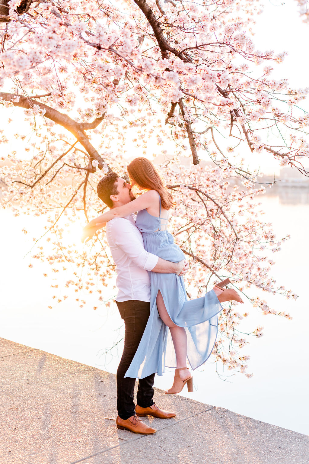 peak bloom cherry blossoms engagement, cherry blossoms engagement photos, DC peak bloom cherry blossoms, DC cherry blossoms photography, DC cherry blossoms photographer, ethereal cherry blossoms photos, DC cherry blossoms, Rachel E.H. Photography, man lifting woman, womans foot in air, blue maxi dress