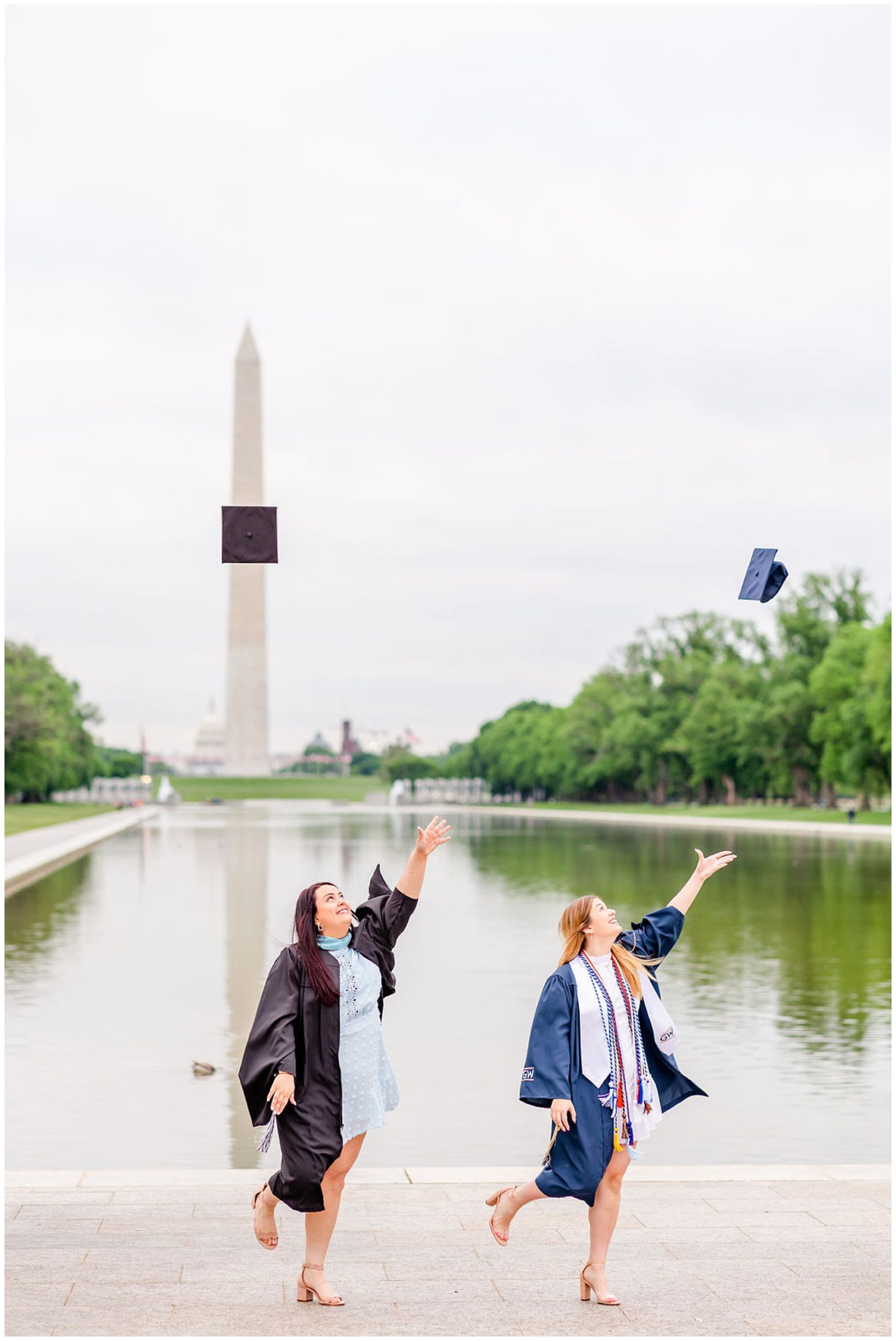 sister graduation photo session, Lincoln Memorial graduation photos, sibling graduation photos, magic hour graduation photos, Washington D.C. graduation photos, D.C graduates, Rachel E.H. Photographer, D.C. graduation photographer, women throwing graduation caps in air, women in graduation gowns, women in front of reflecting pool